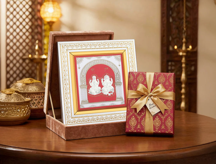 Silver frame featuring carved Laxmi and Ganesh deities, crafted by Bhagwati Jewels for divine home decor display.