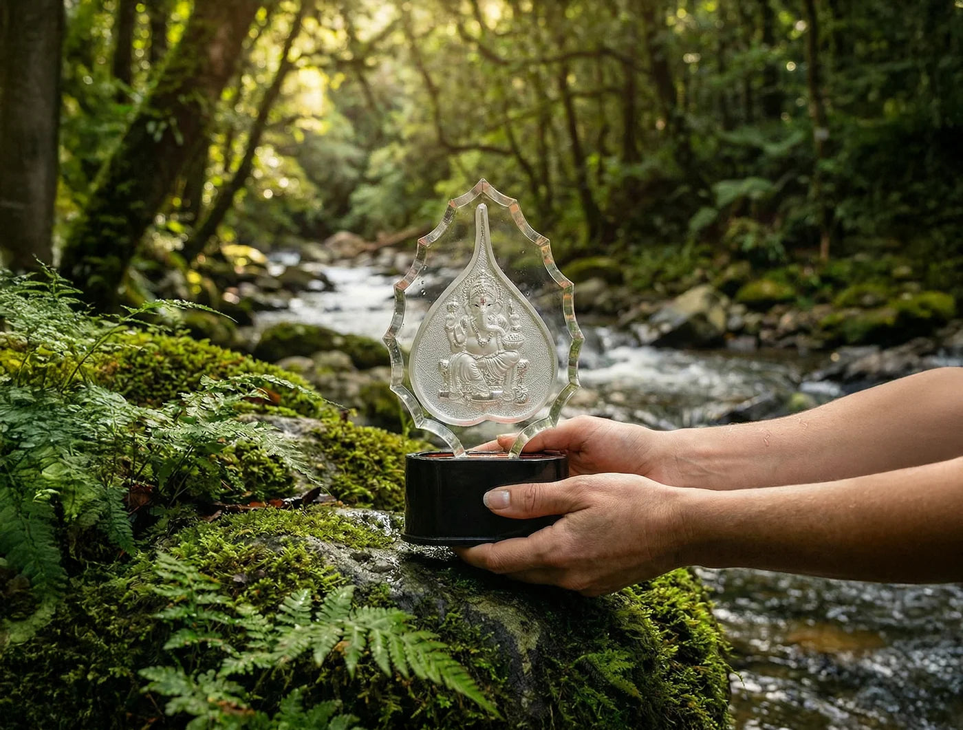 999 Pure Silver Ganesha Trophy Stand displayed in nature beside a flowing stream, showcasing detailed artwork.