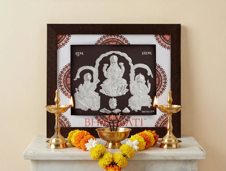 Square silver frame featuring Laxmi Ganesh and Sarswati images, 999 pure silver, for home or office decor, by Bhagwati Jewels.