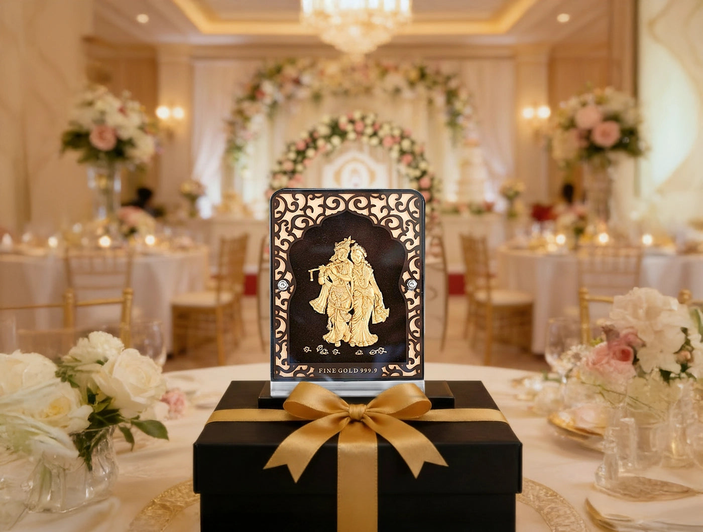 24KT Gold Radhakrishna Tabletop Stand displayed in elegantly decorated event setting with flowers and candlelight.