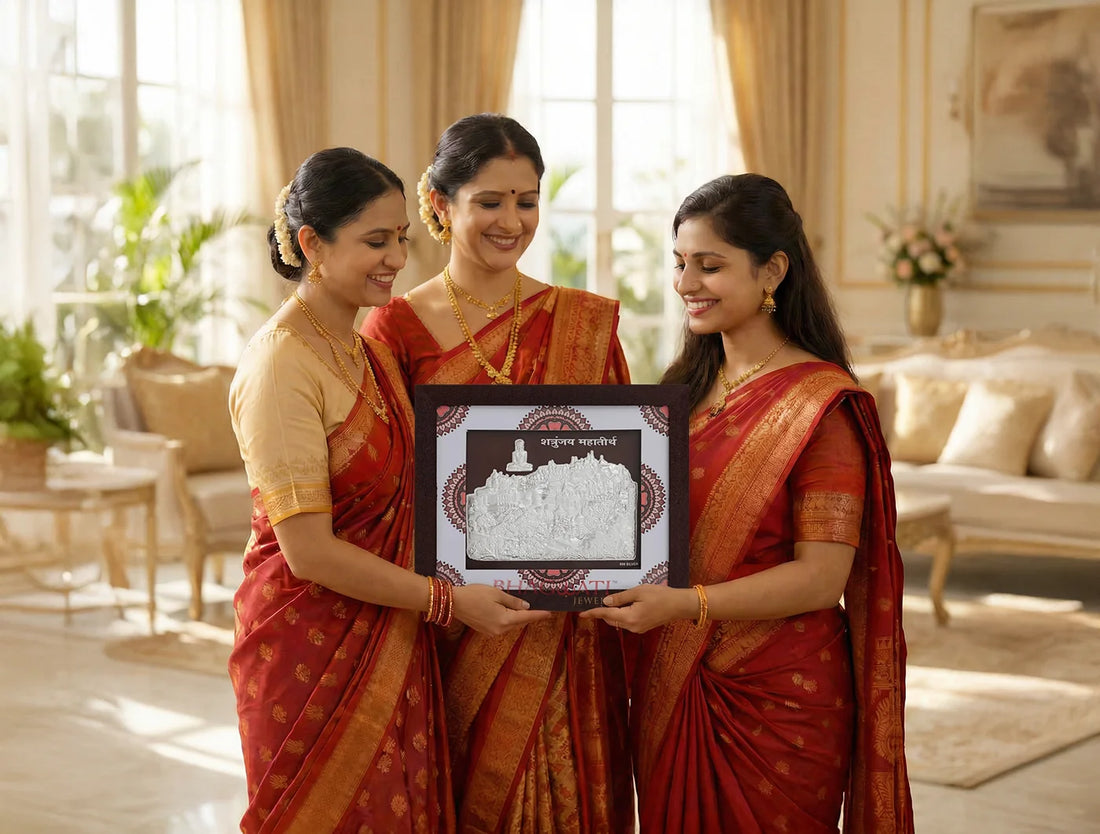Three women in traditional attire holding the 999 Pure Silver Shetrunjay Frame in a beautifully decorated room.